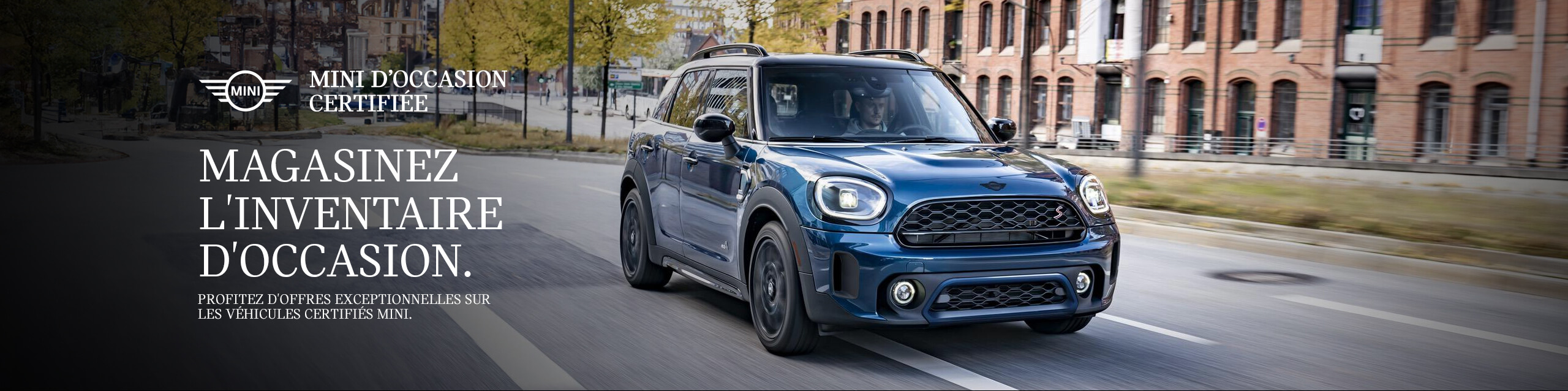 La MINI Countryman stationnée à côté d’un lac avec un homme debout sous la pluie à côté de la voiture.